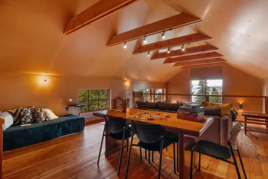 The expansive loft, with its wood-beamed ceilings, features a large desk ideal for playing games, doing puzzles, or working remotely.