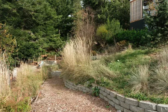 The landscaping at Hillside Haven features charming garden paths and stairways, enhancing the natural beauty of the surroundings.