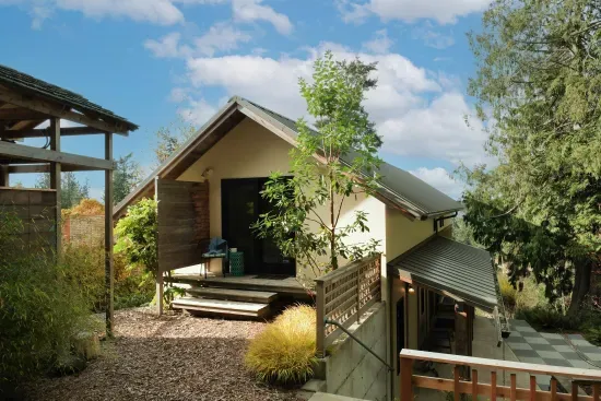 The second-floor King bedroom opens onto a private deck overlooking the serene back garden. At the front entry, you'll find a charming checkered patio and a convenient stairless entry.