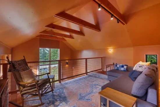 The expansive loft, with its wood-beamed ceilings, features a second day bed and a queen pull out sofa.
