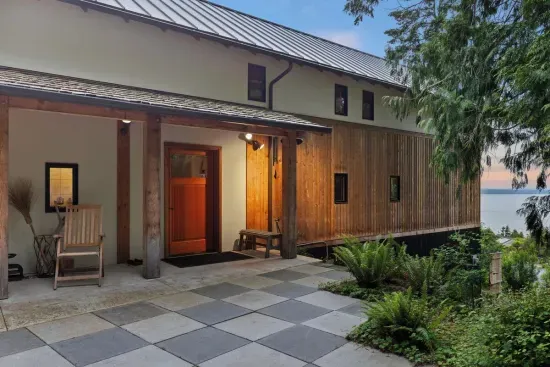 The stairless entry features elegant checkered patio pavers and offers a lovely view of the water.