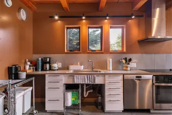 To the left of the sink, a coffee station awaits, featuring a Keurig, a Mr. Coffee maker, a kettle, and a variety of tea bags and Keurig pods.