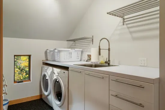 The laundry room with full sized appliances and sink.