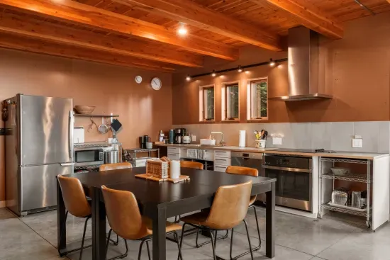 The open-concept kitchen and dining area, with wood beam ceilings and stainless steel appliances, are fully equipped to meet all your needs.