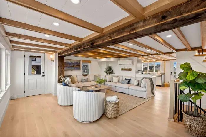 Bright open living space with rustic beams and cozy, stylish seating