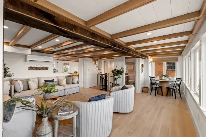 Bright open living space with exposed beams and cozy dining area