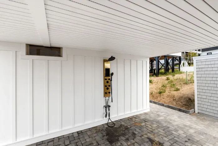 Private covered outdoor shower with modern fixtures and easy beach rinse-off