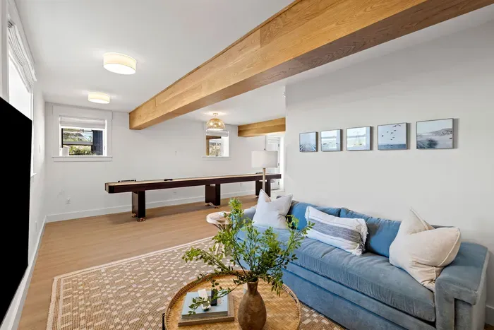 Cozy lounge with shuffleboard, stylish seating, and warm wood beam accents