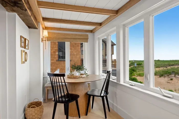 Sunny dining nook with coastal views and charming exposed wood beams