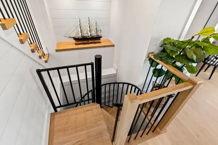 Modern stair landing with spiral staircase, wood accents, and stylish décor