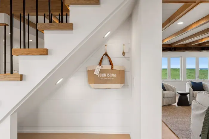 Modern coastal stairway with designer details and bright living room views