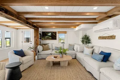 Bright, cozy living room with oversized sectional and rustic wood beams