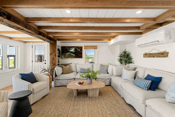 Bright, cozy living room with oversized sectional and rustic wood beams