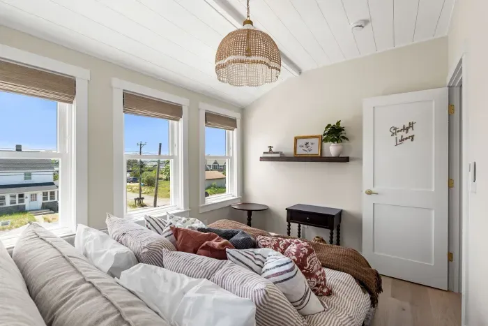 Sunny, cozy bedroom with plush bedding and charming designer touches