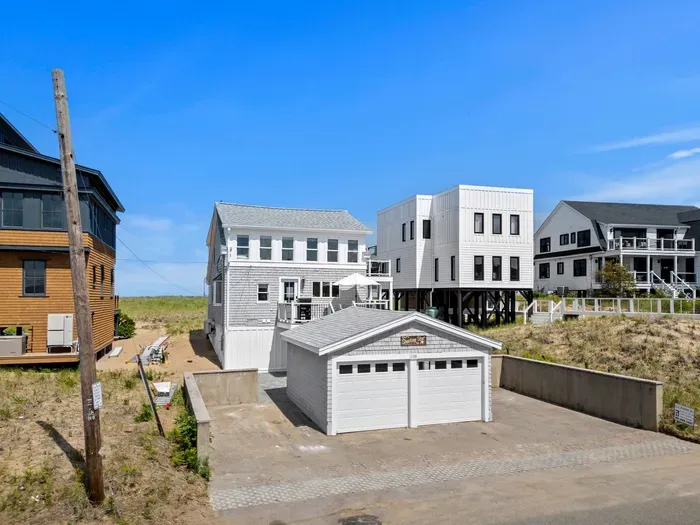 Coastal beach home with detached garage, patio space, and dune-side setting