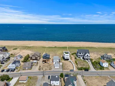 Aerial beachfront views with wide sandy shores and coastal homes