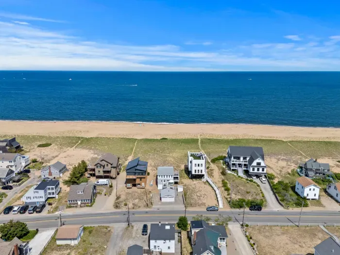 Aerial beachfront views with wide sandy shores and coastal homes