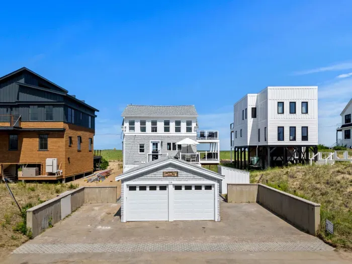 Coastal home with decks, paved drive, and detached two-car garage