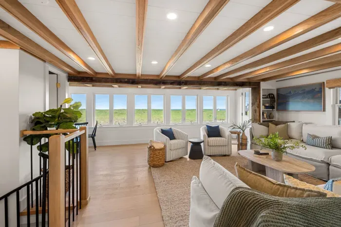 Bright coastal living room with dune views and stylish wood-beam ceilings