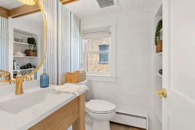 Bright coastal bathroom with gold accents and stylish built-in storage
