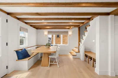 Bright dining nook with built-in seating, wood beams, and smart storage