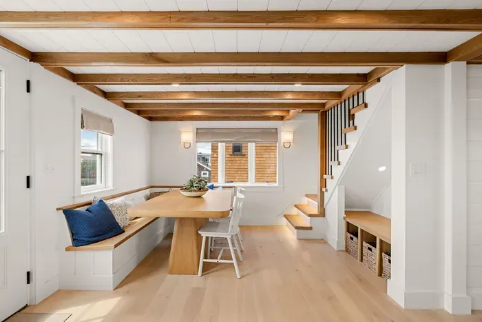Bright dining nook with built-in seating, wood beams, and smart storage