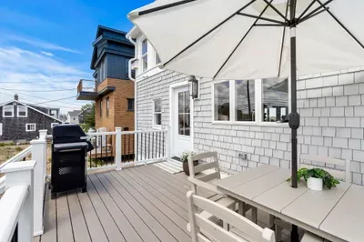 Private sunny deck with grill and shaded outdoor dining