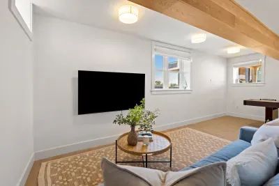 Bright modern lounge with TV, cozy seating, and bonus game space