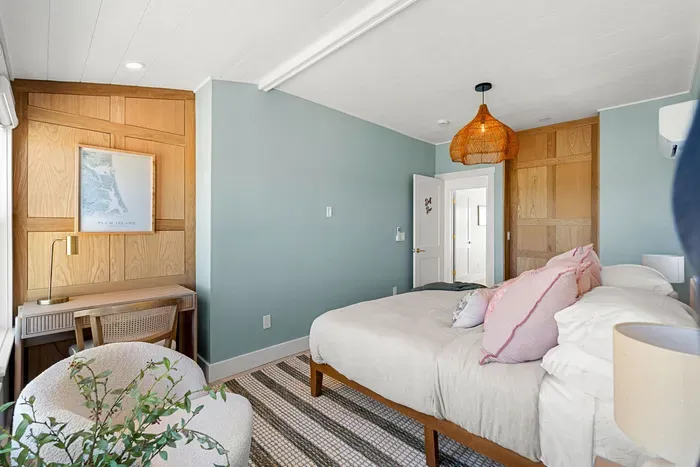 Serene bedroom with king bed, custom wood details, and a cozy desk nook