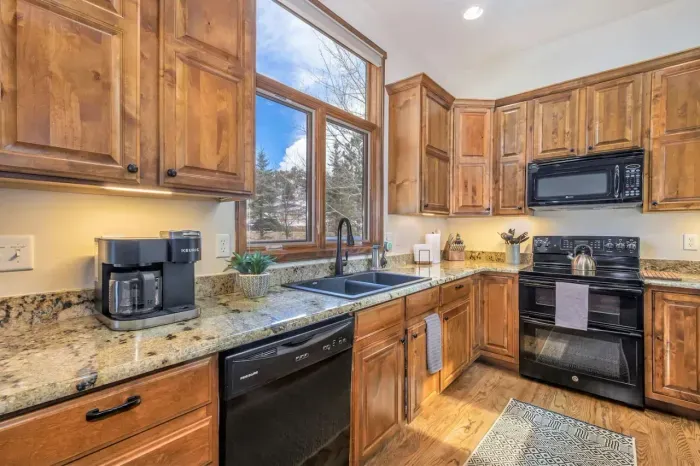 Fully stocked kitchen with Keurig Duo, flat top stove, microwave, and dishwasher.