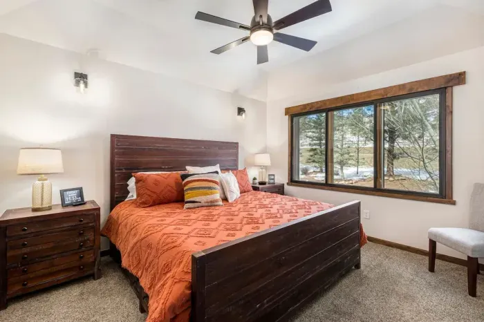 The Primary suite is located on the upper/main level. It has a king-size bed with a memory foam mattress, noise-reducing window panels, a ceiling fan, and black-out shades.