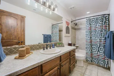 This full bath is on the lower level by bedrooms # 2 and # 3. This bathroom has a tub/shower combo & is stocked with basic cosmetic supplies, emergency feminine hygiene products, a hairdryer, pump shampoo/conditioner, and soaps.