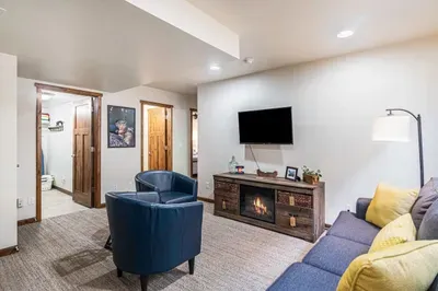 Lower level family room with smart TV and electric fireplace.