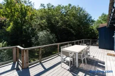 Spacious deck with outdoor dining and peaceful views of the surrounding woods and greenery.