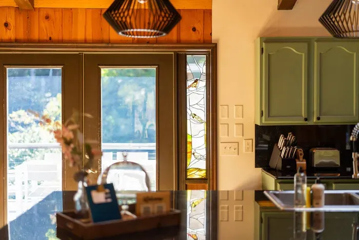 Bright, welcoming kitchen with custom cabinetry, modern appliances, and beautiful natural light from the deck doors.