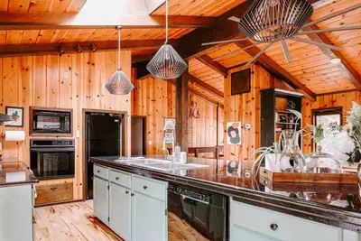 Spacious kitchen with a large island, modern appliances, and beautiful wood-paneled ceilings.