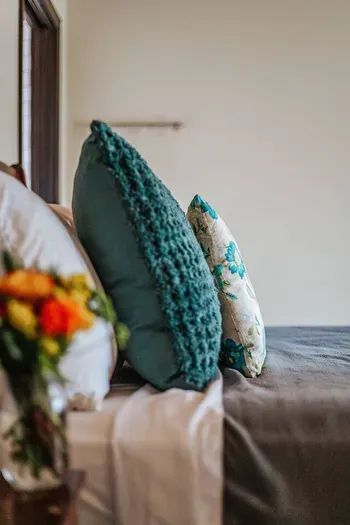 Cozy bedroom details with soft bedding and decorative accent pillows.