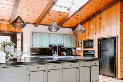 Bright, spacious kitchen with a large island, modern appliances, skylight, and warm wood accents.