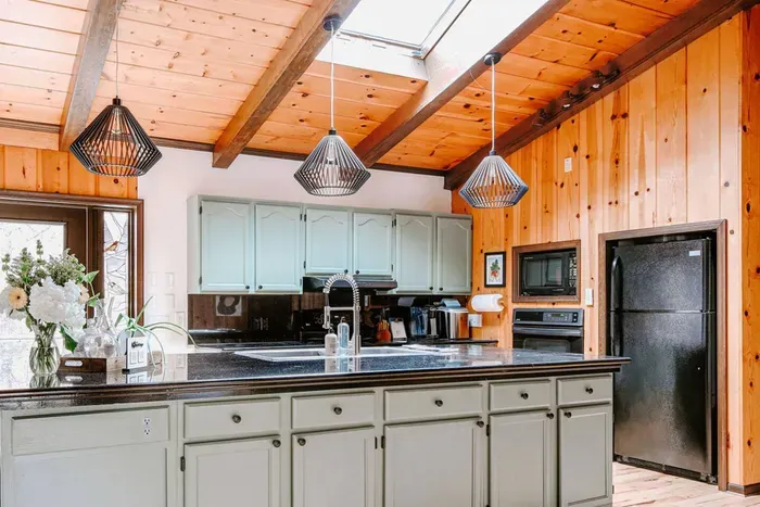 Bright, spacious kitchen with a large island, modern appliances, skylight, and warm wood accents.