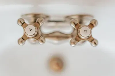 Classic bathroom fixtures with vintage-style brass handles and elegant detailing.