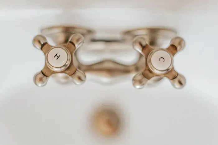 Classic bathroom fixtures with vintage-style brass handles and elegant detailing.