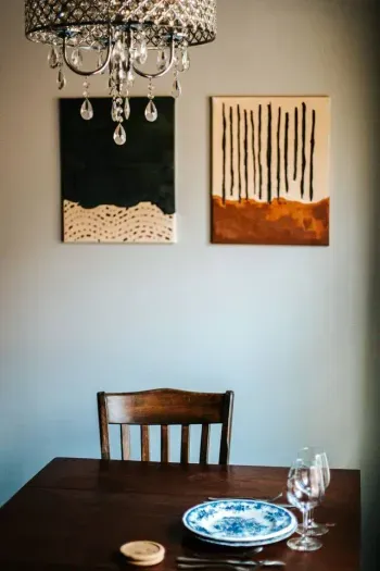 Intimate dining nook with rustic charm, elegant tableware, and a beautiful crystal chandelier.