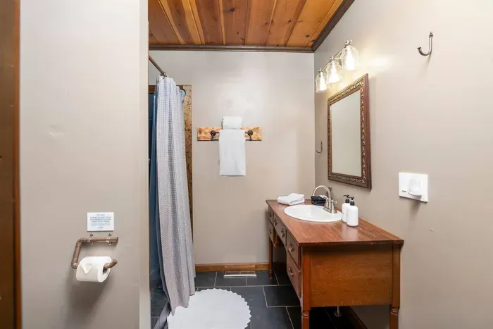 Full Bathroom: Well-appointed bathroom with a spacious vanity, large mirror, walk-in shower, fresh towels, and thoughtful essentials for a comfortable stay.
