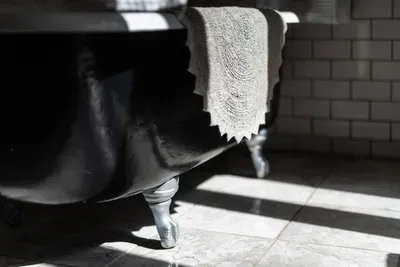 Classic claw-foot tub with elegant detailing, soft textures, and warm natural light.