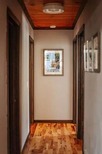 Rustic Hallway: Warm wood accents, hardwood floors, and nature-inspired artwork create a charming, cabin-style welcome.