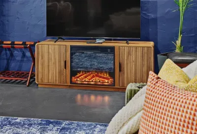 Living area featuring a TV, electric fireplace, and comfortable seating with cozy accents.