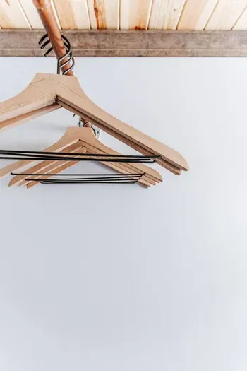 Convenient hanging space with wooden hangers for keeping your clothes organized.