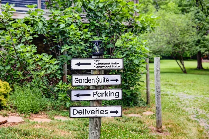 Garden pathway with signs directing guests to the suites, parking, and deliveries.