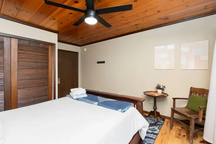 Comfortable Bedroom: Cozy bedroom featuring a spacious bed, fresh linens, warm wood accents, ceiling fan, and a charming sitting nook for relaxing.