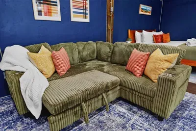Cozy living area with a comfortable sectional sofa, colorful accent pillows, and a soft area rug.
